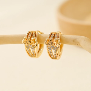Macro detail of golden butterfly hoop earrings with sparkling zircon pave settings
