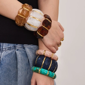 Bracciali larghi in resina color Morandi con dettagli metallici dorati per look elegante