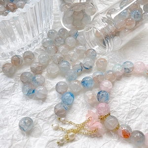 Macro detail of 10mm blue and pink cracked glass beads with floral charm bracelet