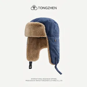 Detailed view of the navy blue canvas exterior and warm camel faux fur lining on trapper hat