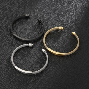 Close-up of mesh textured stainless steel C-shape bracelets in gold, silver and black colors