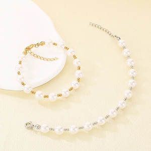 Detail of elegant pearl jewelry set featuring round white pearls with gold and silver clasps