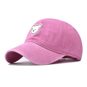Close-up of pink washed cotton baseball cap with cute white bear embroidery detail