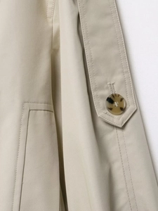 Detail shot of khaki twill fabric with amber buttons and precise stitching on the jacket