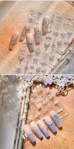 Detailed view of gold leaf nail stickers with blue butterflies and 3D bow designs