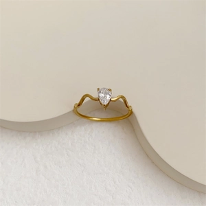 Detailed macro view of teardrop diamond ring with elegant 18K gold plated wavy band design