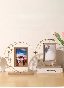 Detail of Nordic gold metal frame with leaf and star accents on a wooden base