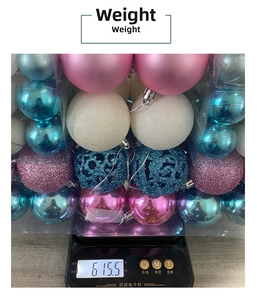 Détail de boules de Noël assorties sur une balance affichant un poids de produit de 615g