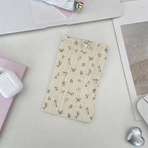 Détail de la pochette en mousseline fleurie avec fermeture à anneau pour petits objets
