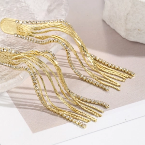 Detailed view of long gold tassel earrings with layered snake chains and rhinestones