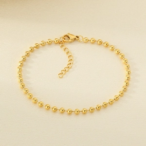 Close-up of a minimalist 18k gold-plated ball chain bracelet with a lobster clasp