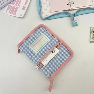 Close-up of blue and white plaid quilted binder cover with pink zipper and front pocket