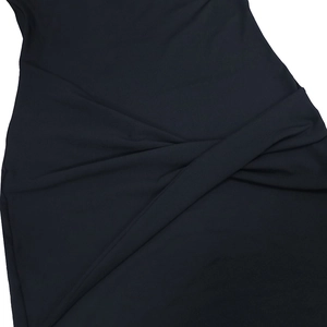 Dettaglio di un abito nero con elegante design a nodo e trama di tessuto a pieghe