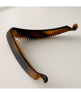 Detail view of the open tortoiseshell banana hair clip showing fine comb teeth and texture