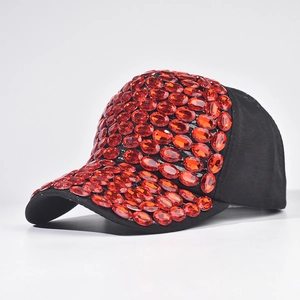 Dettaglio del cappello da baseball artigianale con strass rossi e tessuto in cotone nero