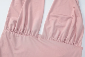 Close-up of pink ruched knit dress featuring deep V-neckline and detailed pleated texture