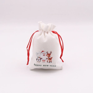 Détail de sacs cadeaux en lin de Noël avec rubans rouges et motifs de dessins animés