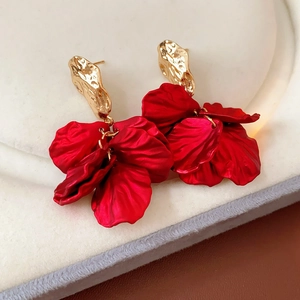 Macro shot of red silk flower petals earrings with irregular gold textured studs