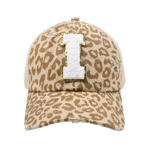 Dettaglio cappello leopardato con lettera I in ciniglia e finiture dall'effetto usurato