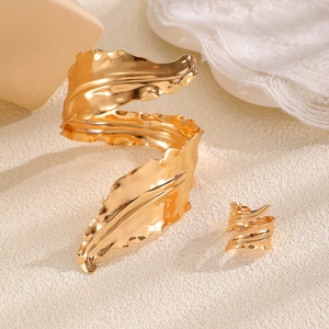 Detailed view of golden leaf cuff bracelet and ring with realistic vein textures
