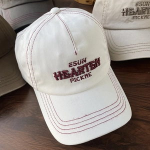 White cotton baseball cap with red letter embroidery and stitched brim details