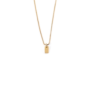 Close-up of a minimalist gold rectangular pendant on a fine box chain necklace