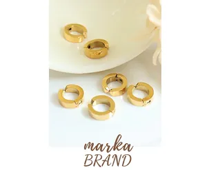 Detailed view of six chunky 18k gold-plated stainless steel ear cuffs on a white ceramic plate