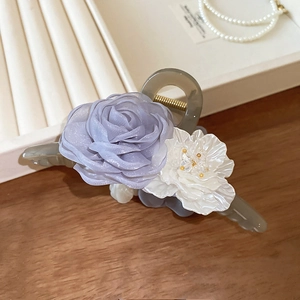 Dettaglio del fermaglio a fiore con petali lilla e base in resina elegante