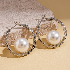 Minimalist silver geometric hoop earrings with pearls displayed on natural stone