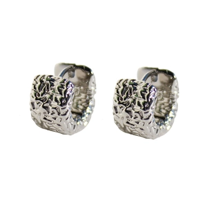 Minimalist silver earrings with irregular lava texture and metallic finish on white background