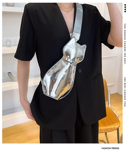 Detail of silver mirror cat-shaped crossbody bag with metallic finish and wide strap