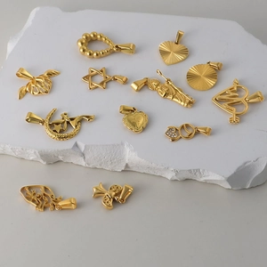 Détails de pendentifs en acier doré en forme de cœur et d'étoile sur plaque de marbre
