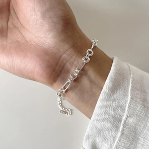 Close-up of a minimalist 925 sterling silver O-link chain bracelet on a woman's wrist
