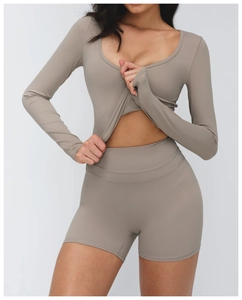 Vue détaillée du haut de yoga à col en V taupe et du short montrant le tissu sans couture