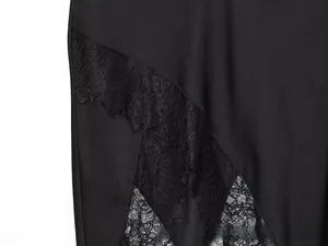 Detailed macro view of black acetate skirt featuring delicate eyelash lace patchwork design