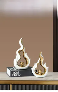 Detail of luxury ceramic flame sculptures with white matte glaze and golden sphere accents