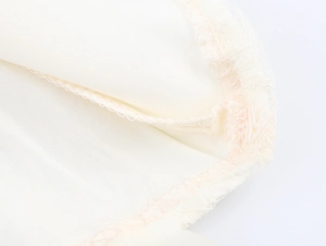 Detail of delicate beige fabric lining with fine overlock stitching and mesh lace edge