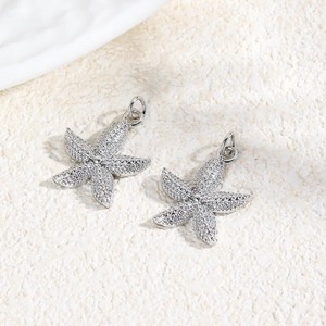 Macro shot of two silver starfish charms with textured metal detail for DIY jewelry