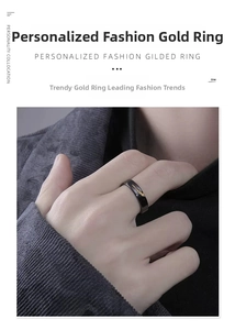 Detail of black and gold plated ring with irregular golden streaks on male model finger