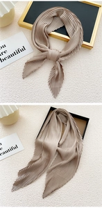 Close-up of champagne pleated satin neck scarf showing fine organza texture and soft folds