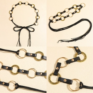 Detail of a black leather belt with golden textured metal rings and knot closure