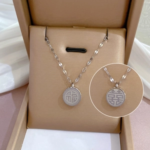 Dettaglio macro della collana in acciaio al titanio argento con pendente tondo Fu e Xi