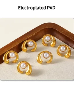 Detailed macro view of PVD gold-plated C-shape earrings featuring polished pearls