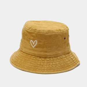 Detail of vintage yellow cotton bucket hat with white heart embroidery and air vents
