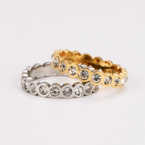 Dual stack of gold and silver stainless steel rings with round crystal inlay on white background