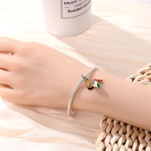 Silver snake chain bracelet with colorful donut and coffee cup enamel charms on wrist