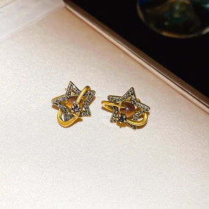 Vintage golden star and Saturn planet stud earring with embedded dark crystals and amber bead