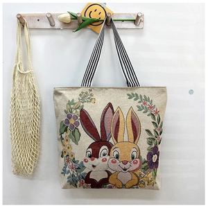 Detail of canvas tote bag with bunny and flower print plus striped shoulder strap