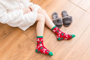 Detail of plush Christmas socks with reindeer patterns in a cozy winter indoor setting