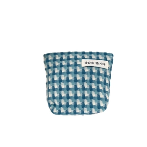 Trousse à carreaux bleu et blanc avec texture tissée et étiquette de marque minimaliste